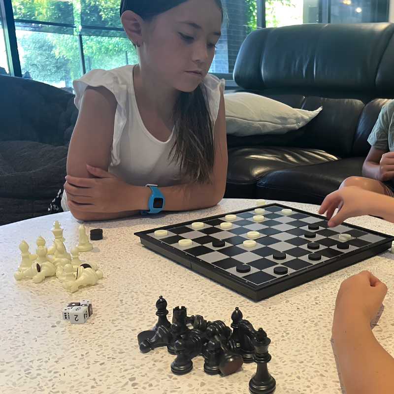 Checkers Magnetic Lifestyle 1 a girl playing magnetic checkers on a white coffee table