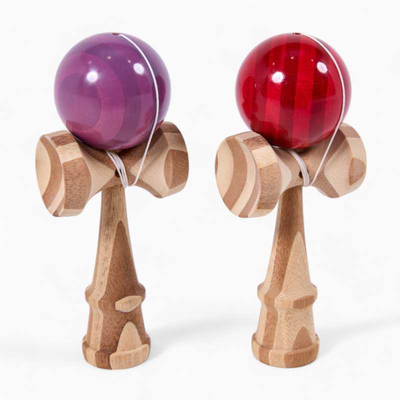 two kendamas one purple and one red, both standing up